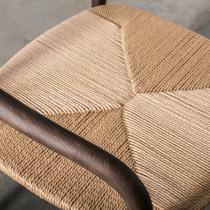 Essence Dining Chair Paper Rope/Smoke close-up view of the paper rope seat and wooden armrest.