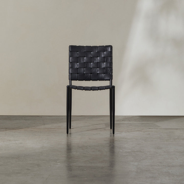 Batali Dining Chair Black with woven leather strappings and elegant metal frame, suitable for dining and gatherings.