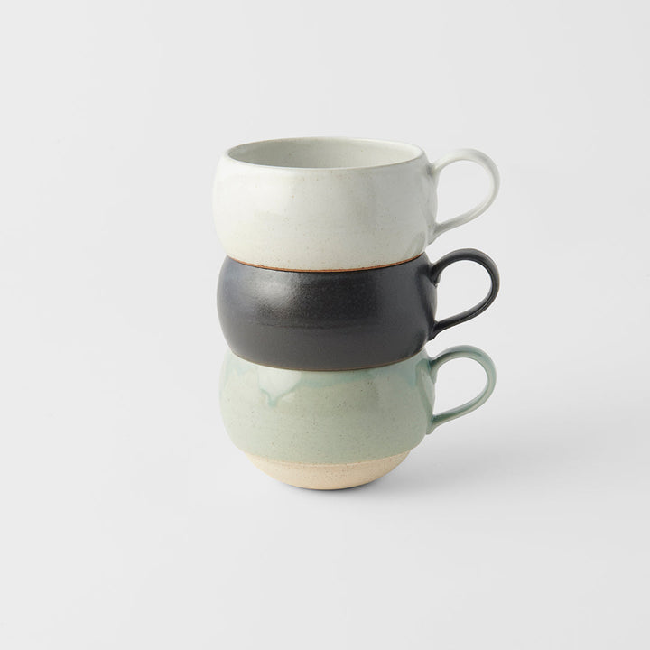Stacked artisan mugs in green, black, and beige glazes, perfect for tea and coffee from Mr Marunaka's family kiln.