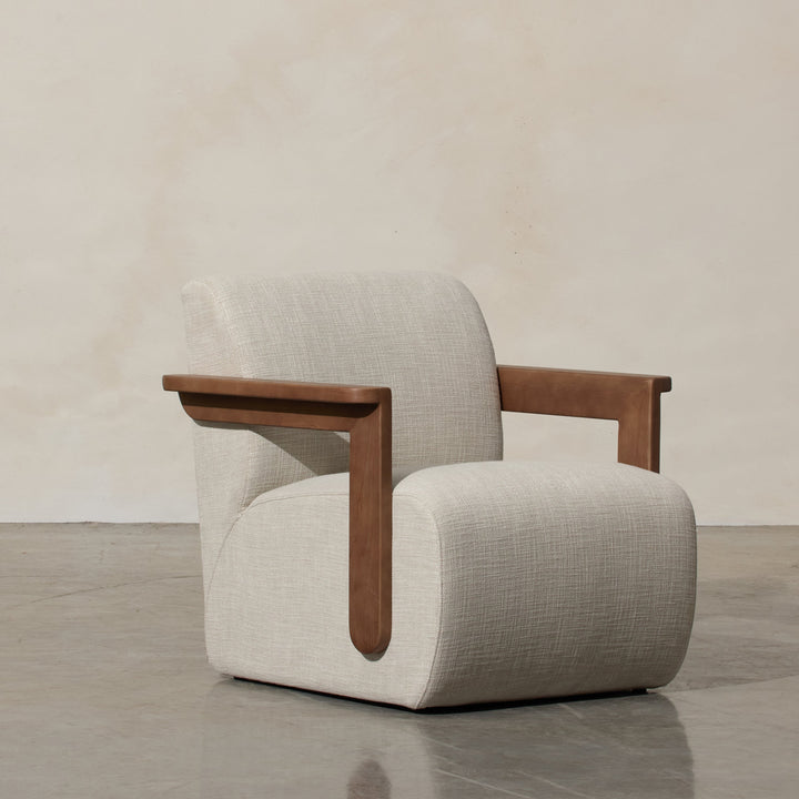 Corwin Occasional Chair Greige Our Corwin Occasional Armchair is mid-century inspired statement piece that blends sculptural elegance and grounded design. This unique upholstere chair features wooden arms that seamlessly extend into the base, eliminating