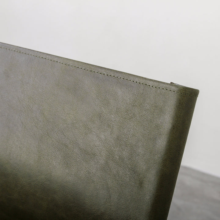 Fieri Dining Chair Olive close-up of olive leather upholstery showcasing quality craftsmanship and design details.