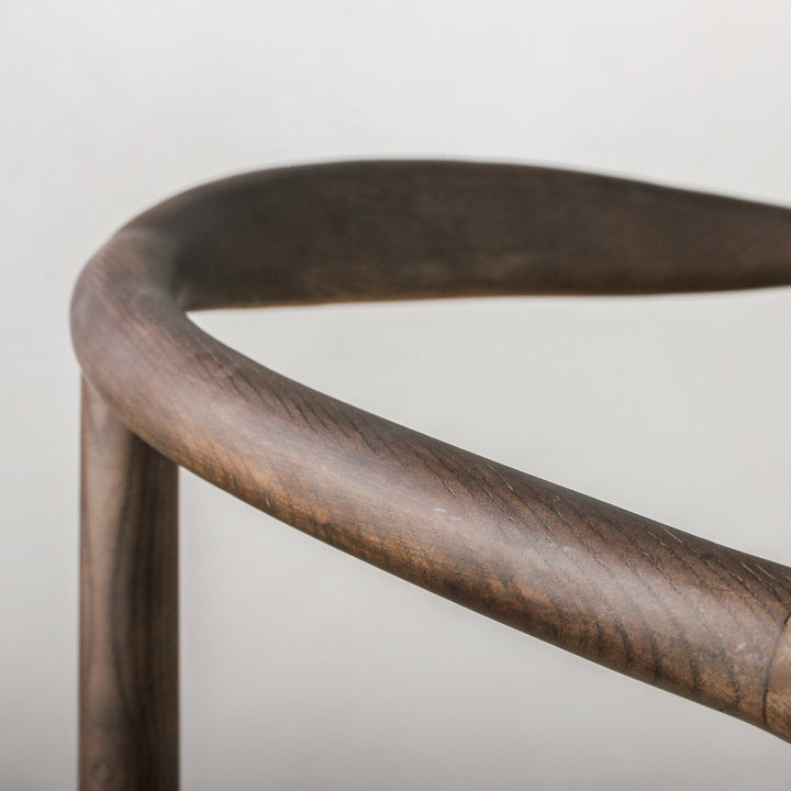 Close-up of the curved Ash wood structure of the Essence Dining Chair Paper Rope/Smoke showcasing its elegant design.
