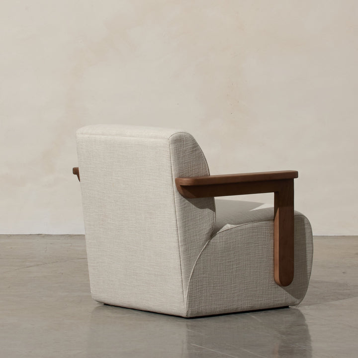 Corwin Occasional Chair Greige Our Corwin Occasional Armchair is mid-century inspired statement piece that blends sculptural elegance and grounded design. This unique upholstere chair features wooden arms that seamlessly extend into the base, eliminating