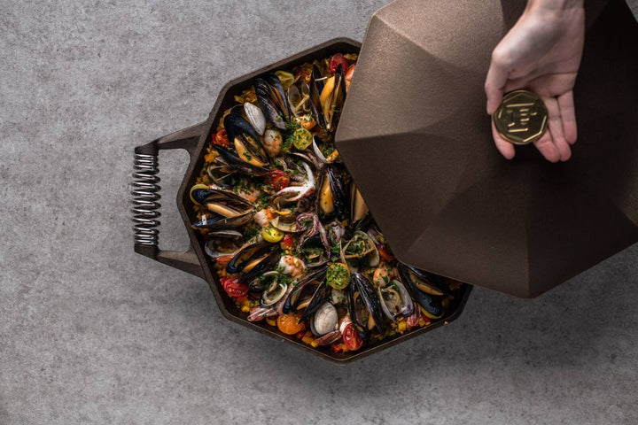 FINEX cast iron skillet with seafood dish, showcasing octagonal shape and polished finish.