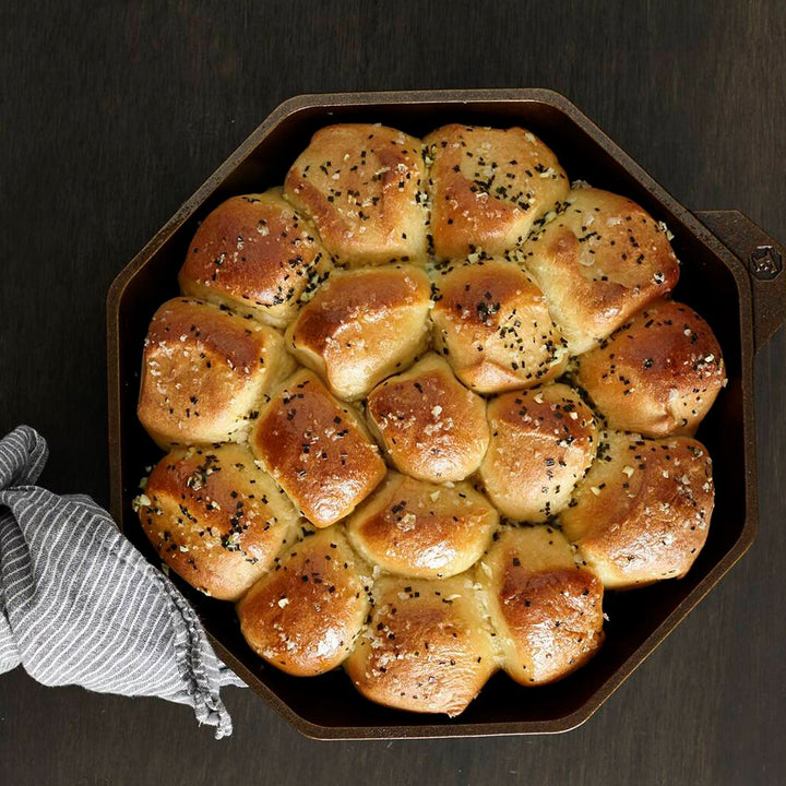 Golden brown rolls baked in FINEX cast iron skillet, showcasing its unique octagonal shape and polished surface.