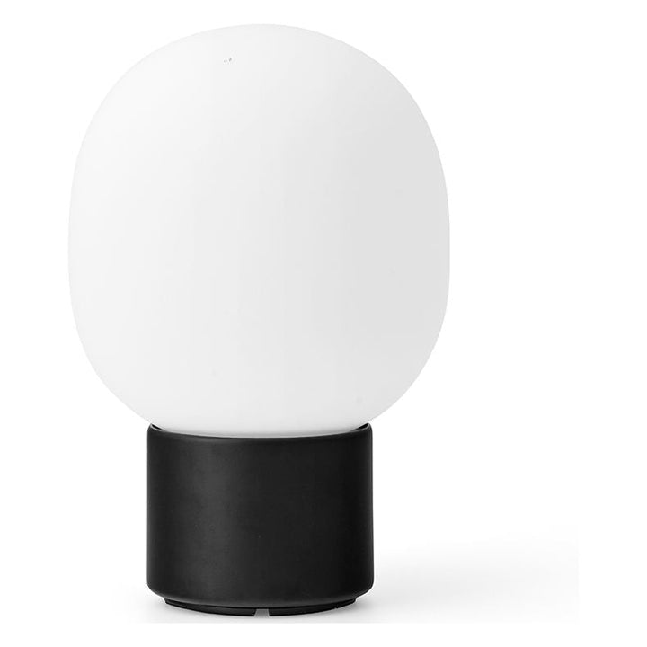 JWDA Portable Table Lamp by Audo Copenhagen - An instant classic, the JWDA Lamp is the kind of sculptural piece that turns heads and brings new life to a room. The contrast of the delicate, rounded glass with the sturdy metal base makes for a balanced and