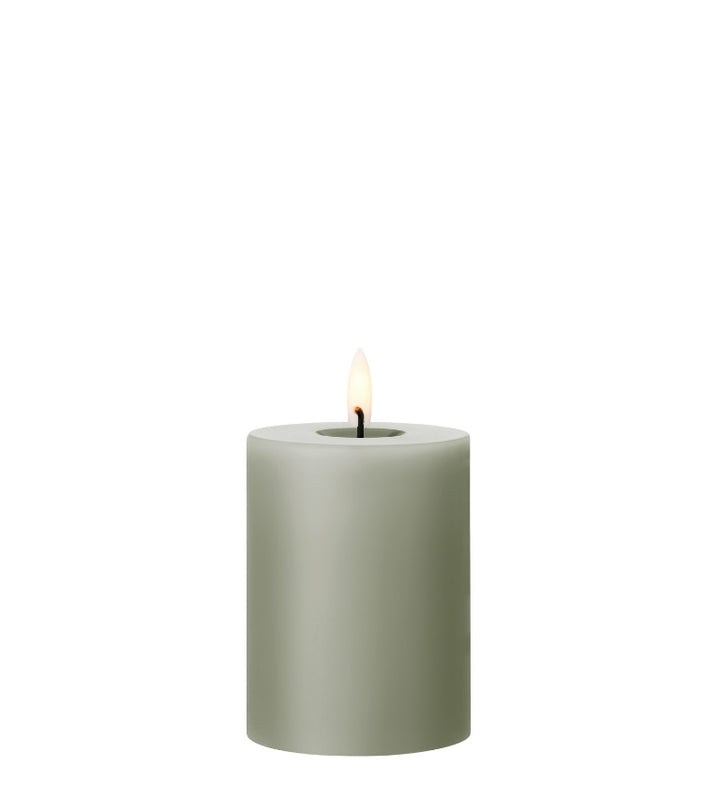 Ester & Erik LED pillar candle in soft green with lifelike glow, ideal for elegant decor and special occasions.