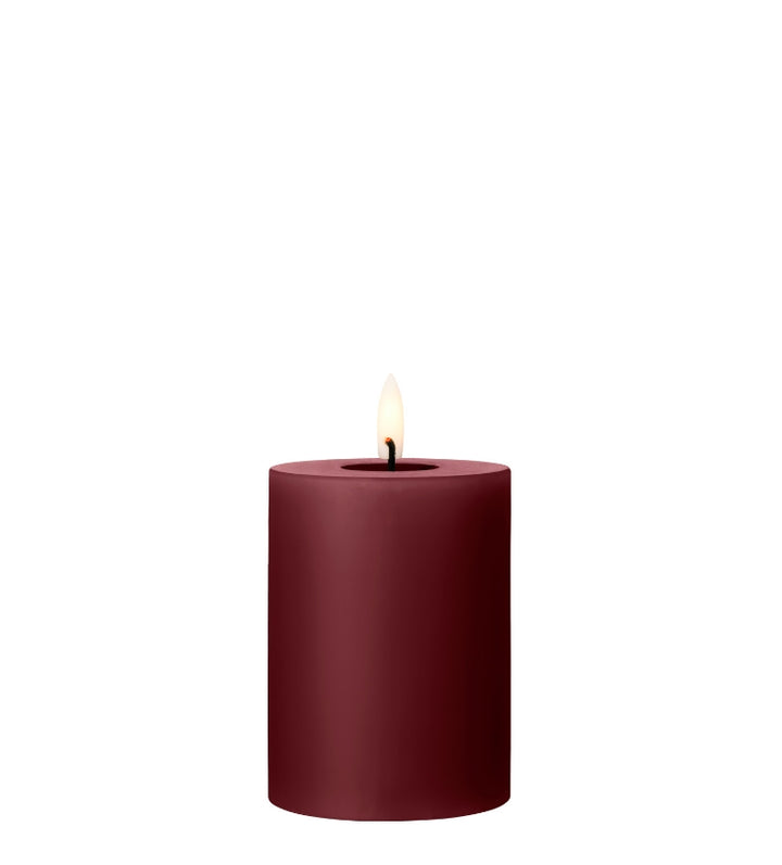 Ester & Erik burgundy LED pillar candle with lifelike glow, perfect for luxurious decor and special events.