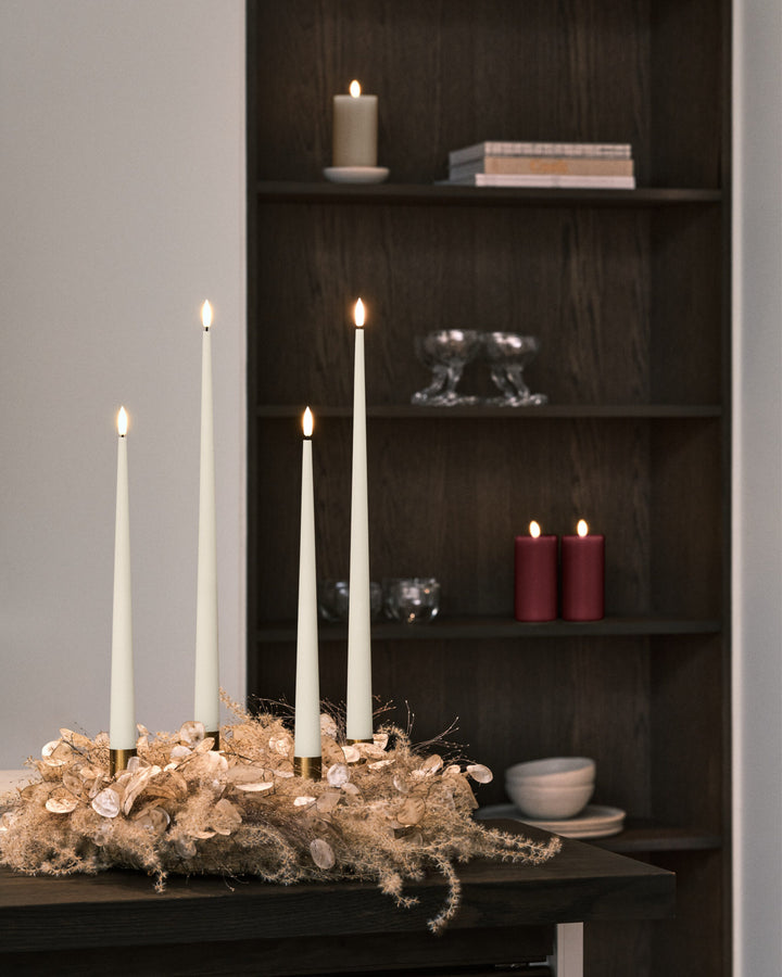 Ester & Erik LED taper candles set on a stylish table arrangement, illuminating a modern interior with elegance.