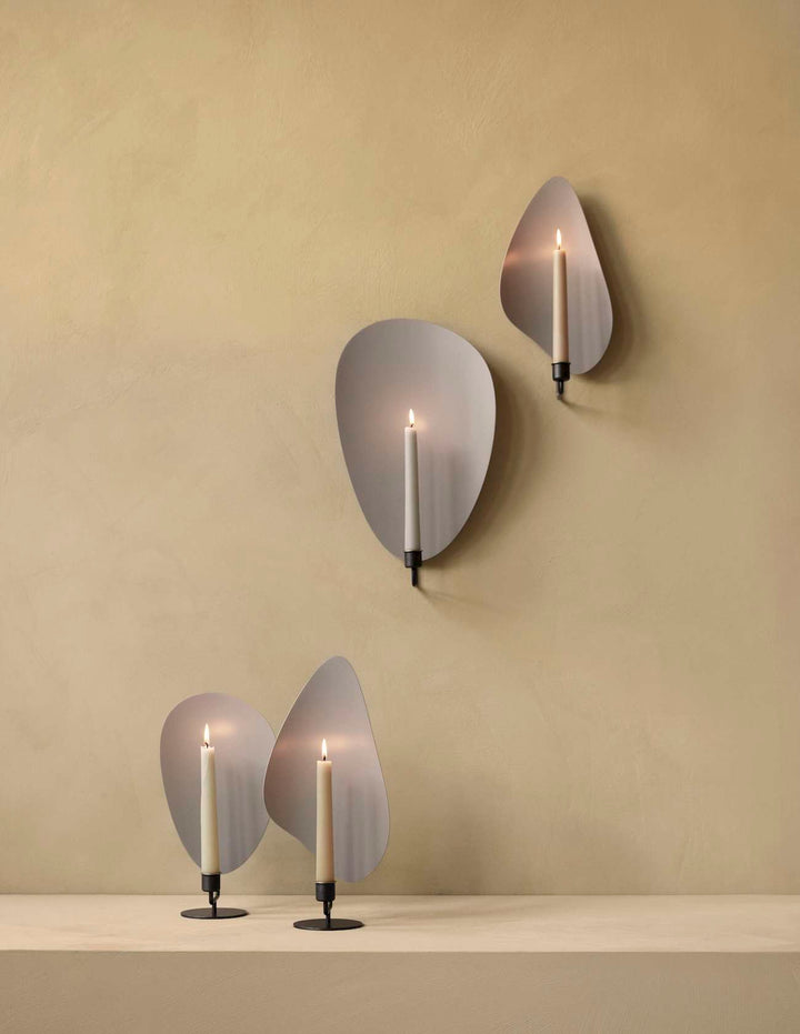 Flambeau Table Candle Holder by Audo Copenhagen - Inspired by French modernist lighting fixtures and designed to resemble a flickering flame, Flambeau is a sculptural design with playful presence. The metal backplate magnifies and reflects candlelight to