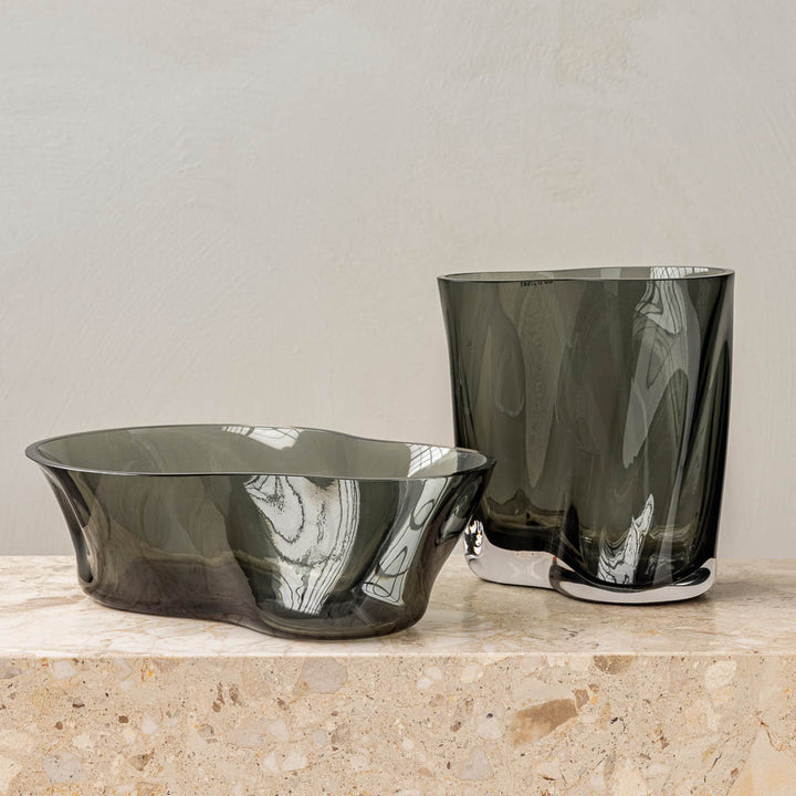 Audo CPH (ex MENU) Aer Bowl, Smoke by Audo Copenhagen - The undulating Aer Bowl in smoke glass brings sculptural appeal to surfaces—whether filled with treats or placed on a surface as a decorative object. Taking its cues from the spiraling movement of ai