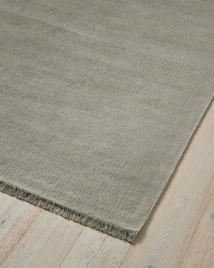 Emilio Flint - Premium Linen Rug for Modern Homes Emilio Flint adds serene sophistication with its grey-blue hue and refined fringe, perfect for contemporary and minimalist spaces.
