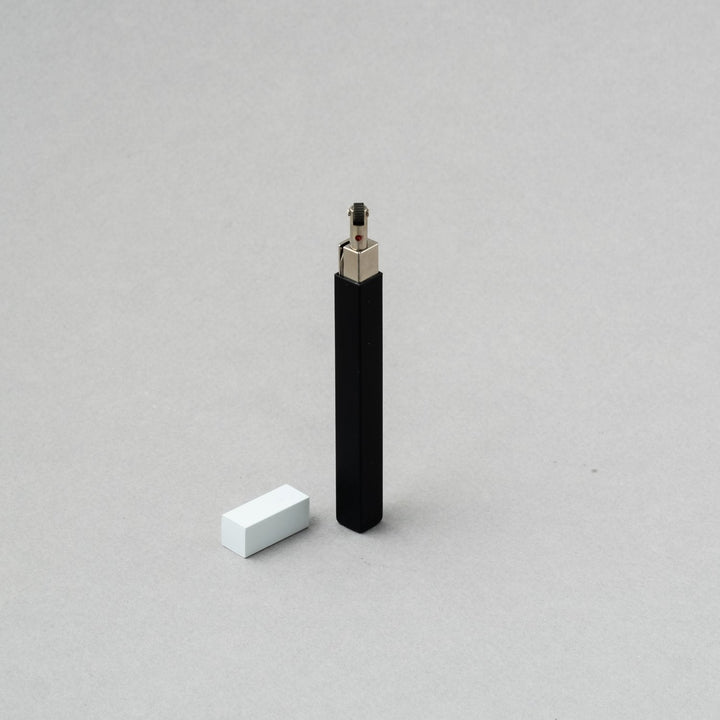 TSUBOTA PEARL Queue Matte Black/White petrol lighter on a gray background, showcasing its elegant design.