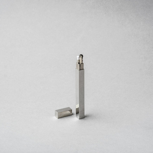 Tsubota Pearl Queue Silver Metal Petrol Lighter elegantly crafted from brass and steel, shown upright with cap beside it.