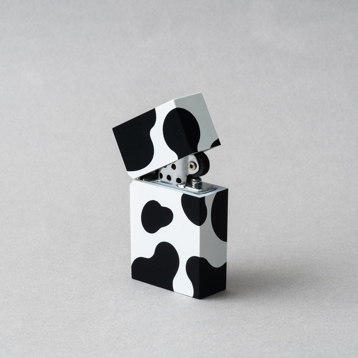 Tsubota Pearl Hard Edge Cow petrol lighter with playful cowhide pattern, handcrafted in Tokyo.