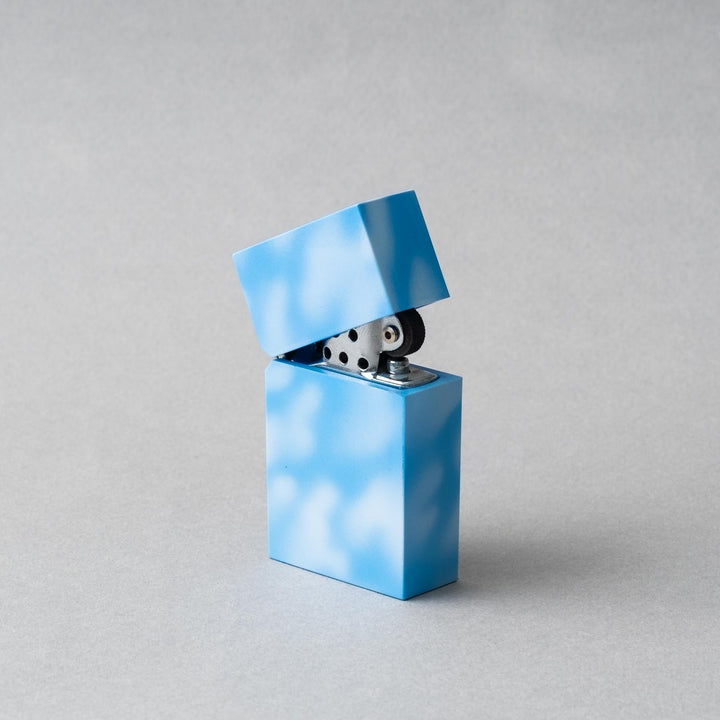 Handcrafted Tsubota Pearl Hard Edge Marble Sky petrol lighter in blue with cloud-like pattern.