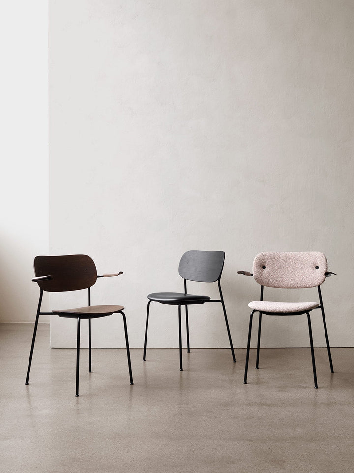 Co Dining Chair, fully upholstered with armrest, Black by Audo Copenhagen - The Co Chair Collection pairs a lightweight, sleek profile with great seating comfort. Available with or without armrests in three wood versions, the versatile design of the fully