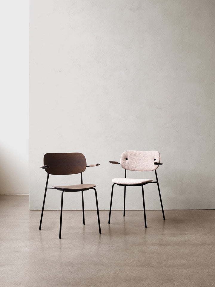 Co Dining Chair, fully upholstered with armrest, Black by Audo Copenhagen - The Co Chair Collection pairs a lightweight, sleek profile with great seating comfort. Available with or without armrests in three wood versions, the versatile design of the fully