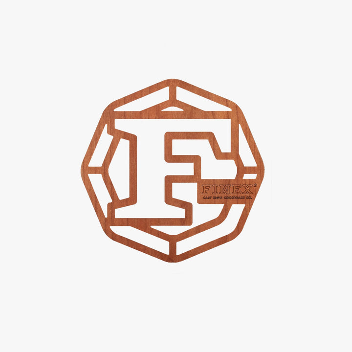 FINEX 8" cherry wood trivet featuring laser-cut logo, designed for elegance and surface protection.