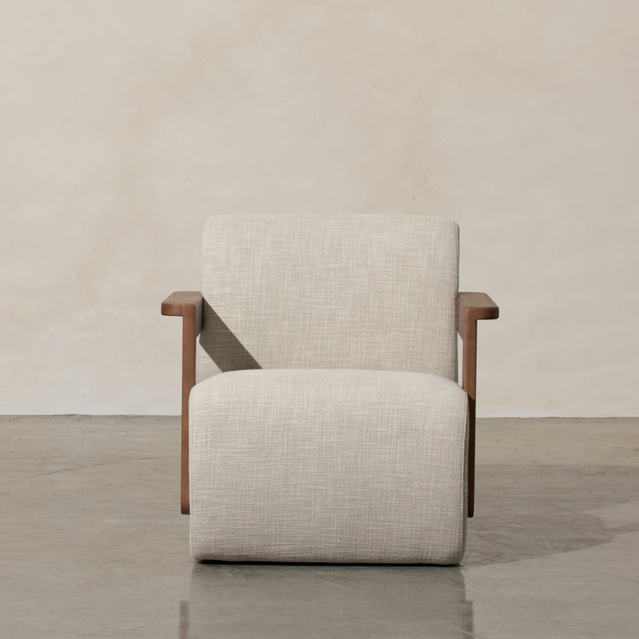 Corwin Occasional Chair Greige Our Corwin Occasional Armchair is mid-century inspired statement piece that blends sculptural elegance and grounded design. This unique upholstere chair features wooden arms that seamlessly extend into the base, eliminating