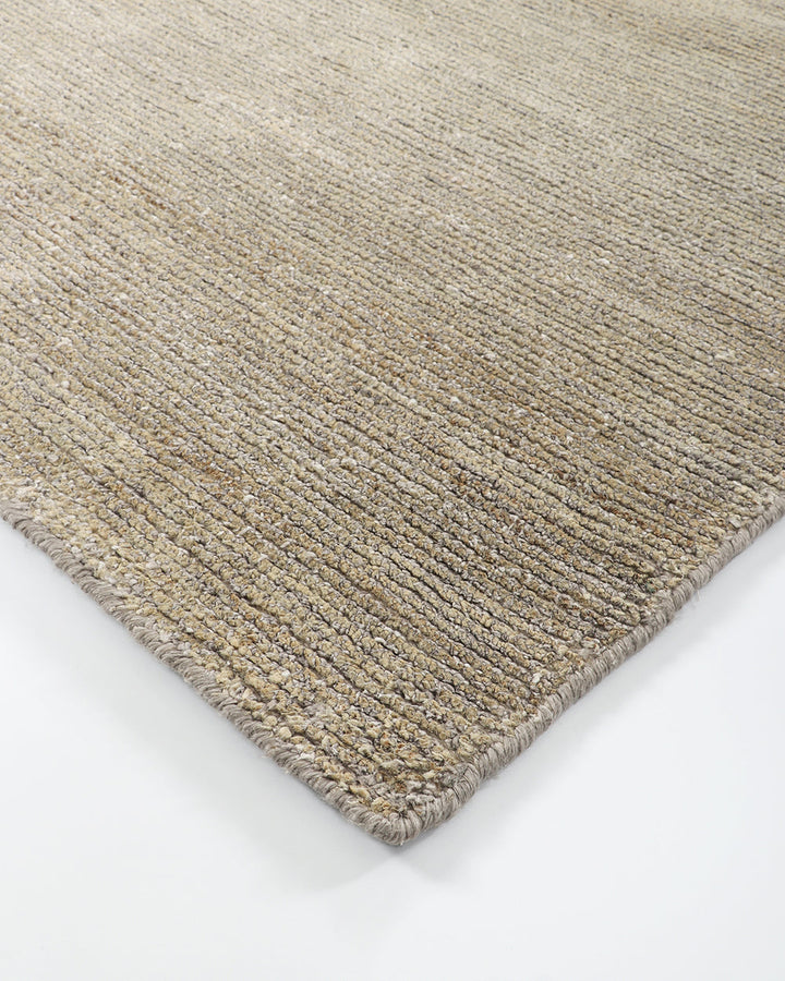 Anchorage Floor Rug Bring nature into your home with this handmade floor rug woven in natural fibres. A blend of bamboo silk and jute yarns gives the tufted surface subtle colour graduations, while the golden sand tone lays the foundation for a thoughtful