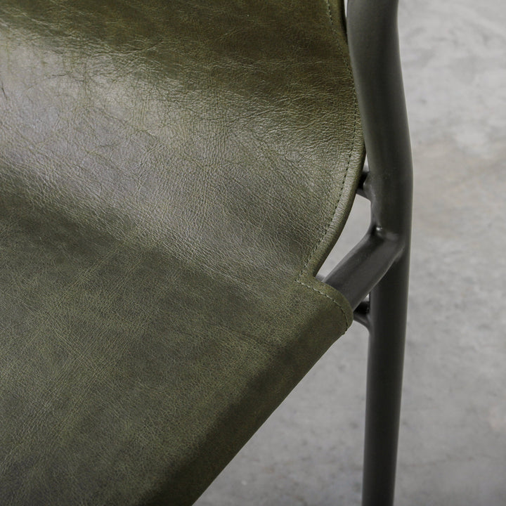 Fieri Dining Chair Olive close-up, showcasing premium olive leather upholstery and industrial metal framework.