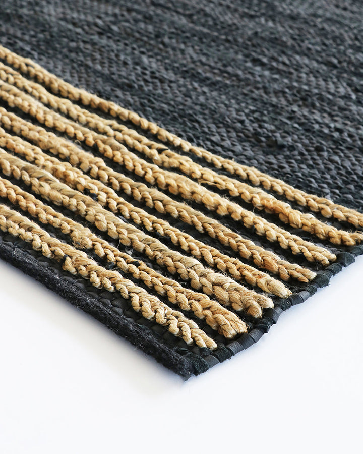 Bogota Floor Rug A contemporary take on leather, the Bogota creates visual interest through raw texture, depth of colour and simple design. Handwoven from soft strips of black leather, braided jute detailing is then applied on both ends to finish this pie