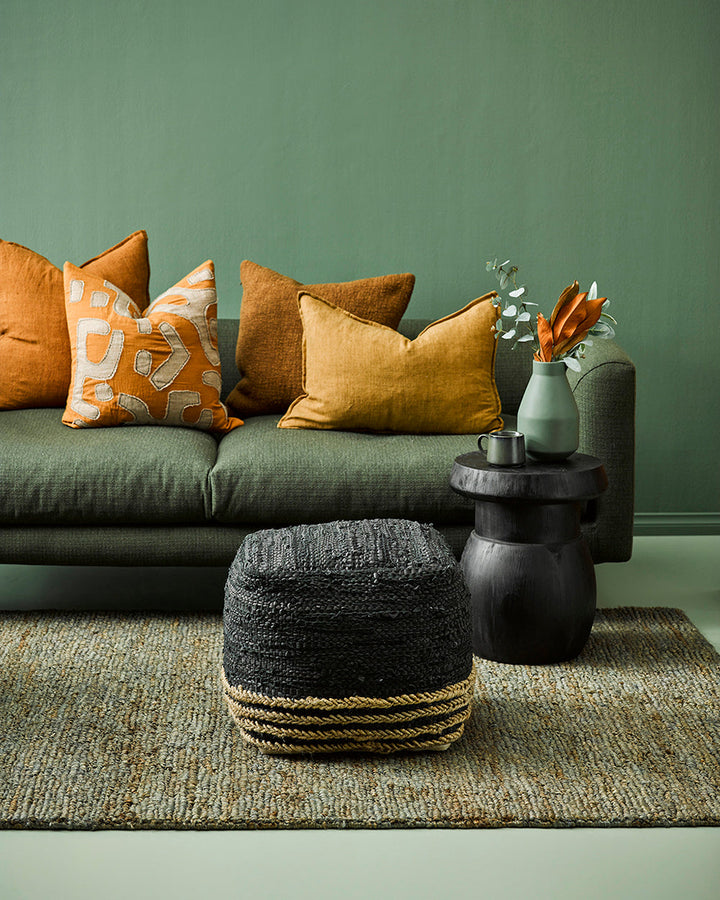 Bogota Ottoman Invite raw texture into your space with the distinctive beauty of our Bogota ottoman. Crafted from soft black leather with braided jute detailing, the hard-wearing nature and rustic texture of this piece creates a laid-back, artisan aesthet