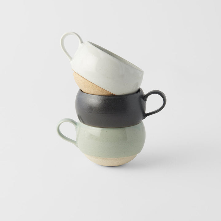 Stacked sphere mugs in black, green, and white glaze, ideal for tea and coffee, showcasing artisan craftsmanship.