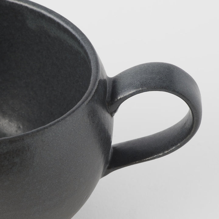 Close-up of black glaze sphere mug with handle by Mr Marunaka, artisan tableware for tea and coffee.