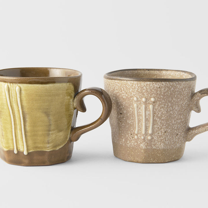 Mug set in earth tones, featuring a green and a beige mug with unique glaze designs
