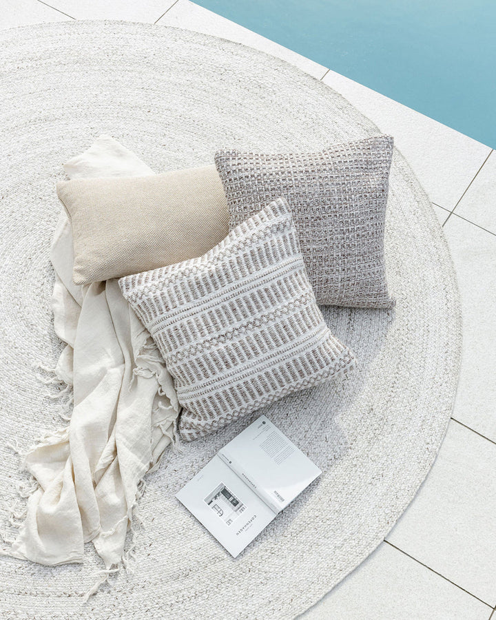 Elton Cushion A natural, artisan aesthetic is reflected in the stunning design of this outdoor cushion. Handwoven from soft PET yarn (derived from recycled plastic bottles), the Elton features a classic basketweave texture in speckled hues of cocoa, ecru