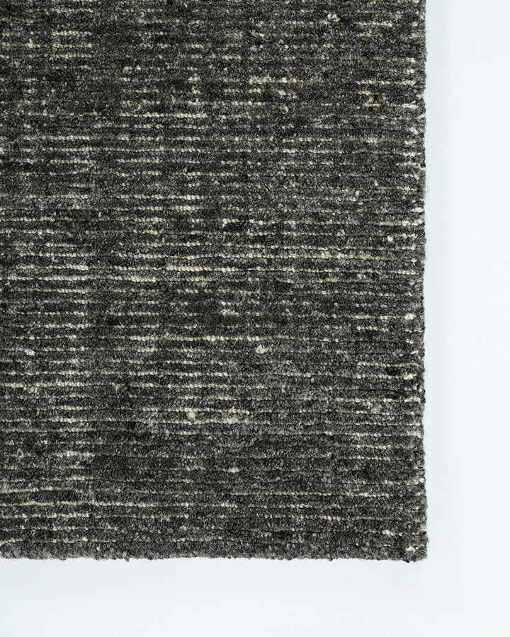 Emmett Floor Rug An understated floor rug that is both simple and luxurious. The Emmett is hand-knotted from 100% wool, creating a soft minimal pile. Featuring a fine linear pattern with a lighter base tone, this floor rug is perfect for crafting a refine