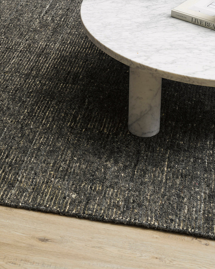 Emmett Floor Rug An understated floor rug that is both simple and luxurious. The Emmett is hand-knotted from 100% wool, creating a soft minimal pile. Featuring a fine linear pattern with a lighter base tone, this floor rug is perfect for crafting a refine