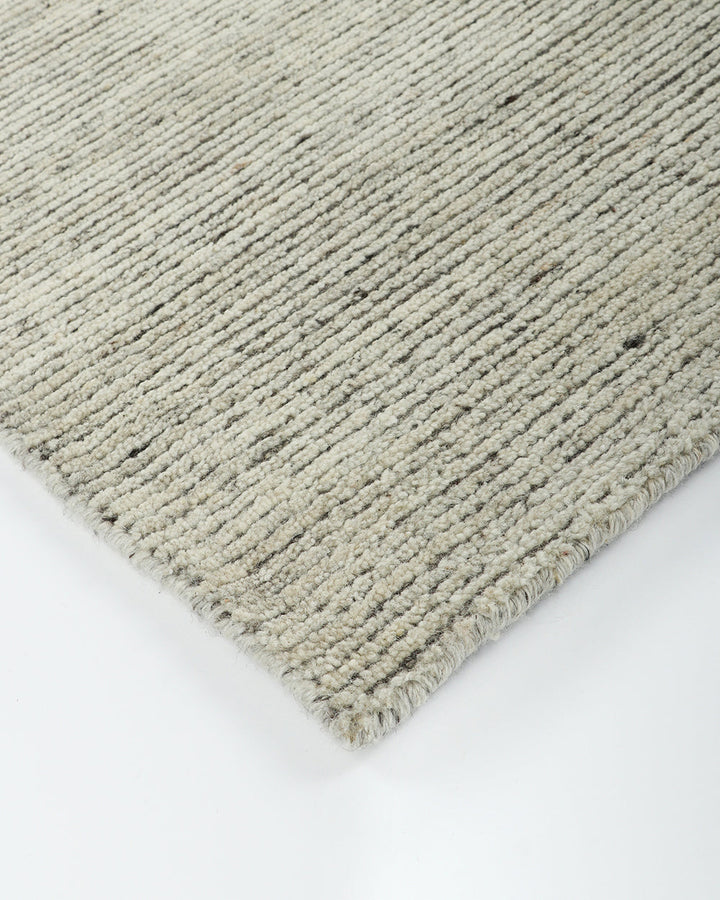 Emmett Floor Rug An understated floor rug that is both simple and luxurious. The Emmett is hand-knotted from 100% wool, creating a soft minimal pile. Featuring a fine linear pattern with a lighter base tone, this floor rug is perfect for crafting a refine