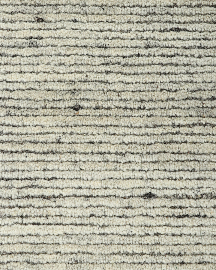 Emmett Floor Rug An understated floor rug that is both simple and luxurious. The Emmett is hand-knotted from 100% wool, creating a soft minimal pile. Featuring a fine linear pattern with a lighter base tone, this floor rug is perfect for crafting a refine