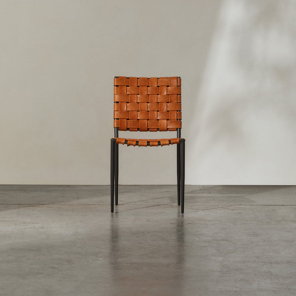 Batali Dining Chair Tan showcasing woven leather strapping and modern metal framework in a contemporary setting.