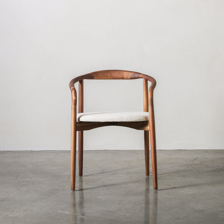 Essence Dining Chair Fabric/Walnut showcasing its elegant curved walnut frame and soft fabric upholstery.