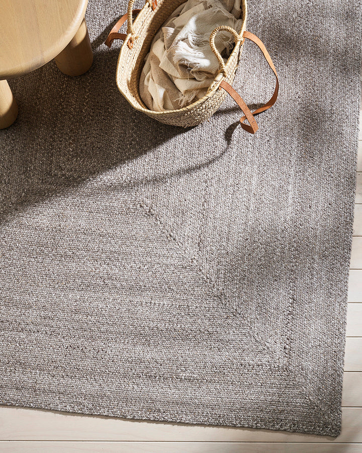 Flinders Floor Rug Indulge in the beauty of understated design. Flinders features a gently mottled texture, handbraided into a subtle linear pattern with mitre point corners. Handcrafted by skilled artisans, the sustainable PET composition is soft and dur