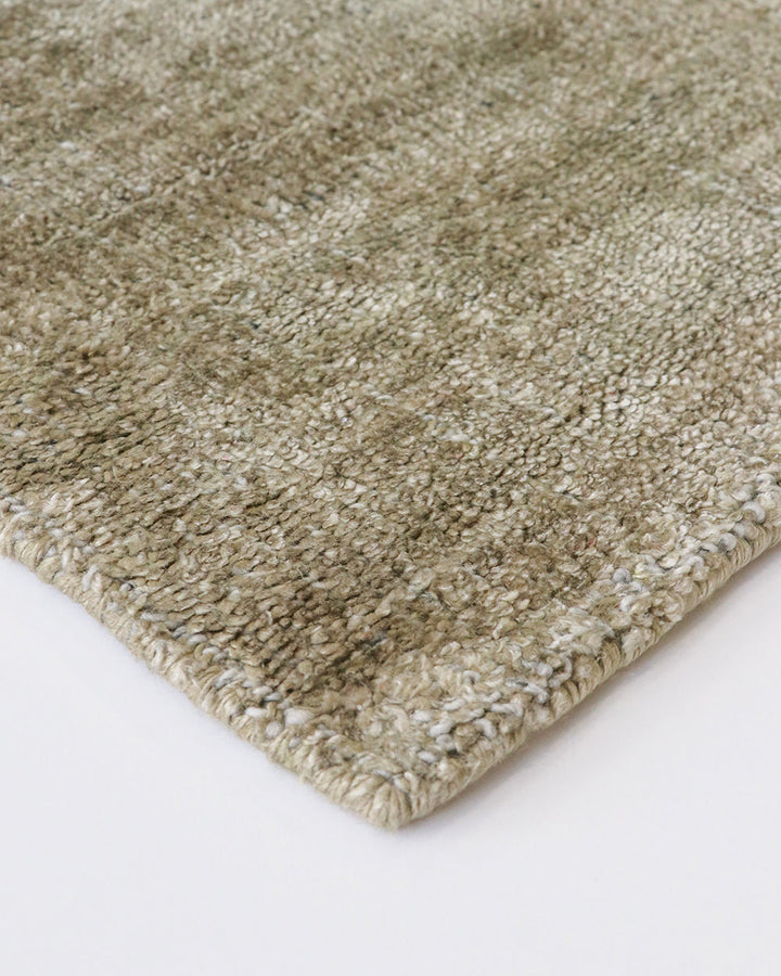 Gratus Floor Rug Indulge in the subtle sheen, rich fibre, and silky underfoot texture of Gratus. Handcrafted from a stunning blend of bamboo silk and wool, the muted gold colouring is complemented by a darker base undertone. Beautifully soft, the gentle l