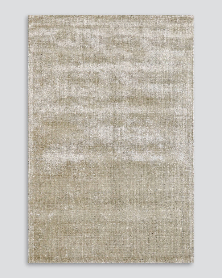 Gratus Floor Rug Indulge in the subtle sheen, rich fibre, and silky underfoot texture of Gratus. Handcrafted from a stunning blend of bamboo silk and wool, the muted gold colouring is complemented by a darker base undertone. Beautifully soft, the gentle l