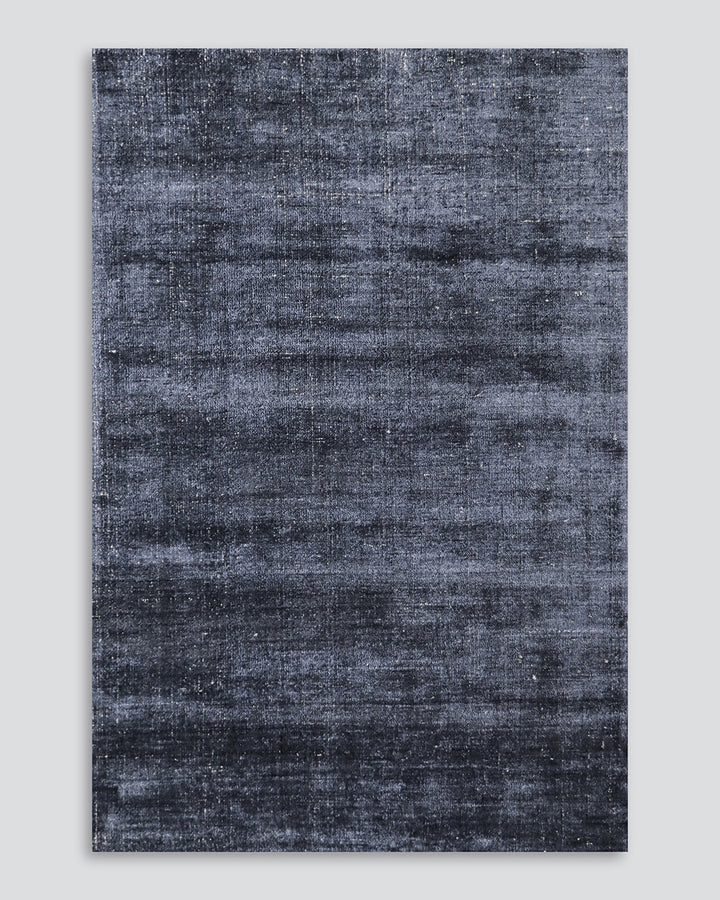 Gratus Floor Rug Indulge in the subtle sheen, rich fibre, and silky underfoot texture of Gratus. Handcrafted from a stunning blend of bamboo silk and wool, the muted gold colouring is complemented by a darker base undertone. Beautifully soft, the gentle l