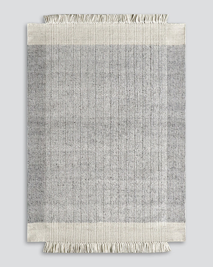 Lindis Floor Rug Add understated chic to your interior with the exceptional design of our Lindis floor rug. Handwoven by skilled artisans, tonal fibres are woven in a classic 1-1 structure, creating a refined and interesting border design. Fringing on bot