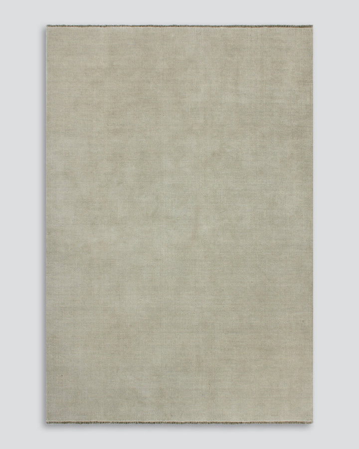 Sandringham Floor Rug Create a sophisticated sanctuary with the dense, sumptuous pile of the Sandringham. Soft and supportive underfoot, this floor rug is handknotted from 100% wool, featuring a cut pile and delicate fringing at both ends. The neutral fog