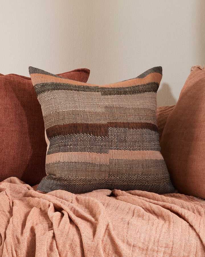 Saratoga Cushion Constructed from sections of artisanal woven fabric, the Saratoga is handwoven using a stunning blend of wild tussar silk and fine wool. Celebrating natural fibres, the earth and subtle peach tones create a globally inspired, artisan aest