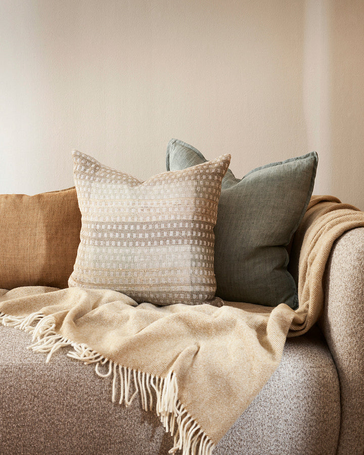 Solano Cushion Celebrating the beauty of artisanal woven fabric, Solano is an exquisite textural piece in shades of muted sage, grey and putty. Handwoven in a silk-linen blend, the delicate surface pattern creates an inviting and serene aesthetic. Pair wi