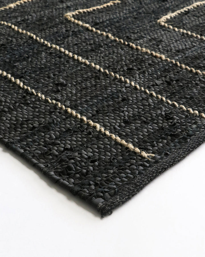 Tunja Floor Rug Ideal for laid-back living spaces, the soft black leather and embroidered jute design of the Tunja makes for a simple and relaxed aesthetic. Pair with handmade objects and textiles for a raw and rustic interior look. Australian Stock Buy a