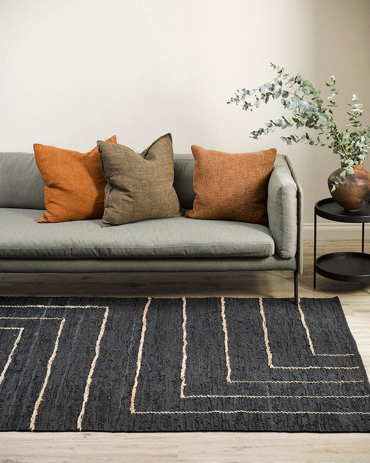 Tunja Floor Rug Ideal for laid-back living spaces, the soft black leather and embroidered jute design of the Tunja makes for a simple and relaxed aesthetic. Pair with handmade objects and textiles for a raw and rustic interior look. Australian Stock Buy a