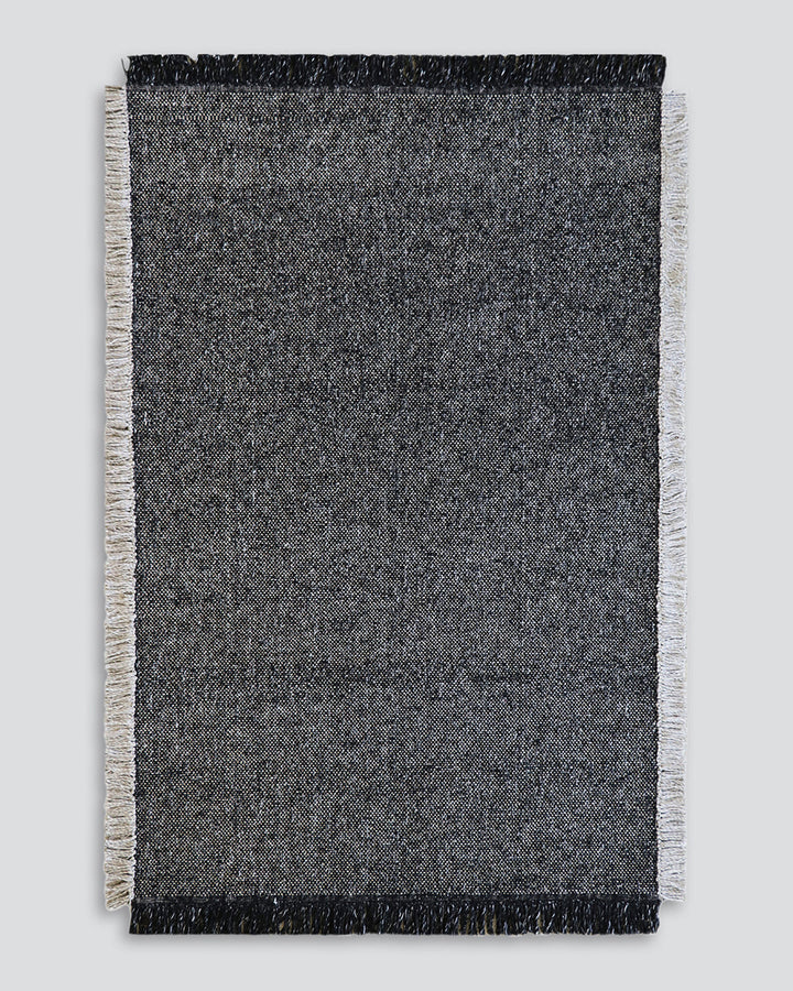 Ulster Floor Rug Create a casual yet refined interior with the subtle texture of the Ulster. Wool and linen fibres are handwoven in a classic 1-1 structure, which are blended in a contemporary monochrome colourway. Two-tone fringing finishes the design, s