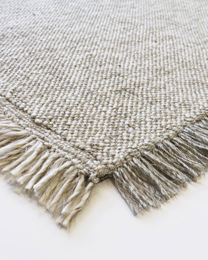 Ulster Floor Rug Create a casual yet refined interior with the subtle texture of the Ulster. Wool and linen fibres are handwoven in a classic 1-1 structure, which are blended in a contemporary monochrome colourway. Two-tone fringing finishes the design, s